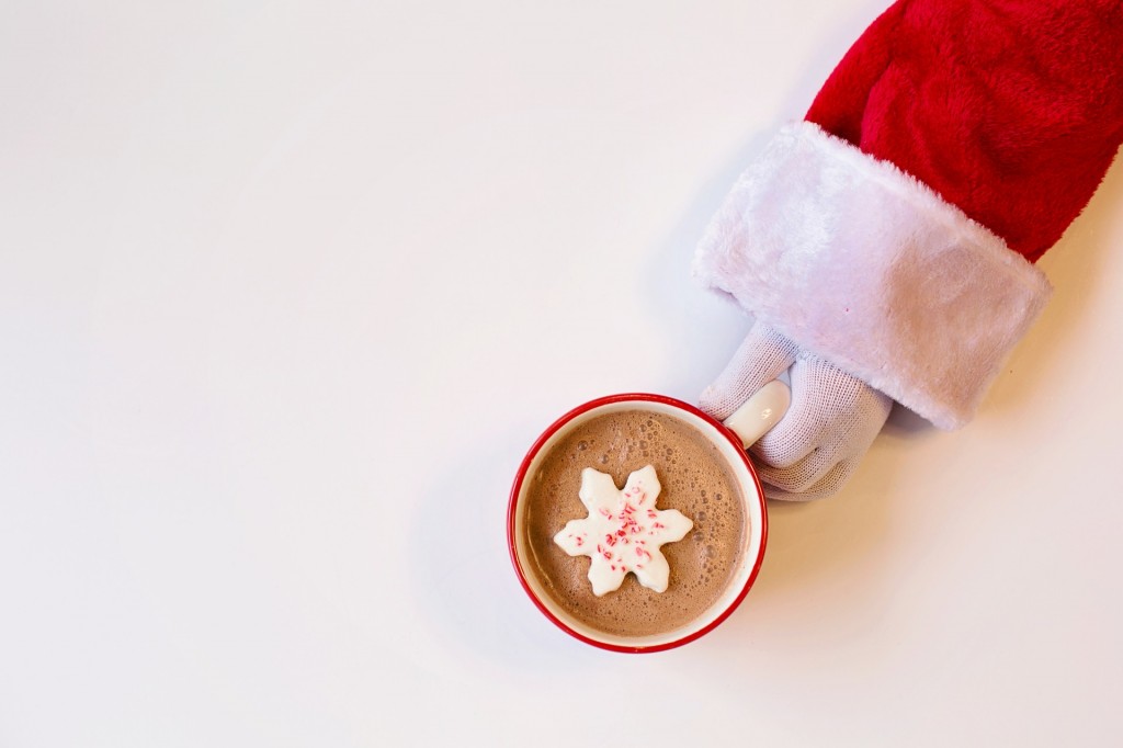santa's hand holding mug of hot chocolate