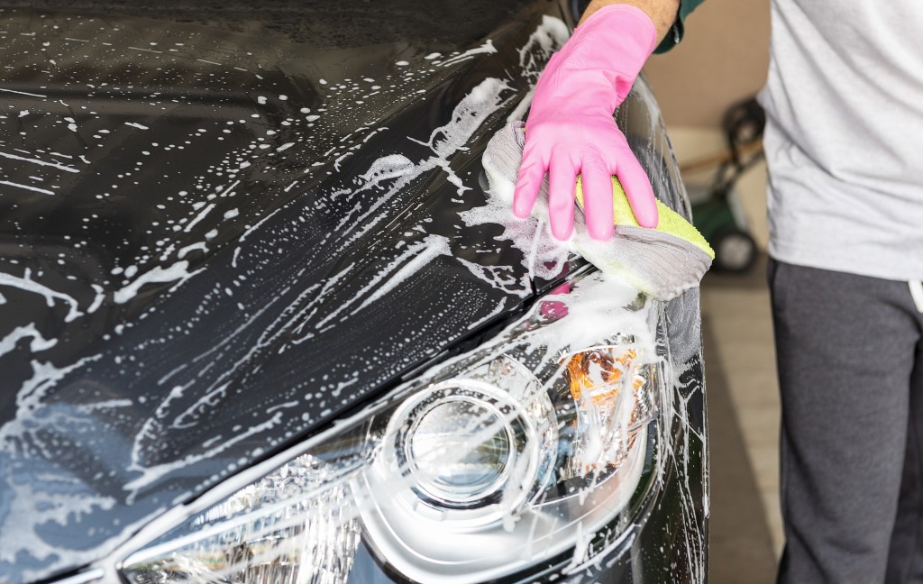 gloved hand washing car