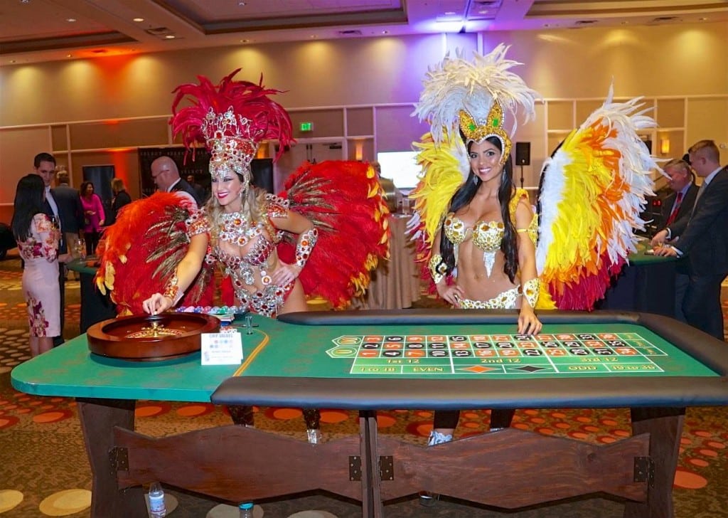 Las Vegas styled and dressed showgirls standing by roulette table at event