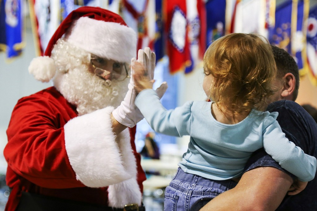 Santa high fiving small child