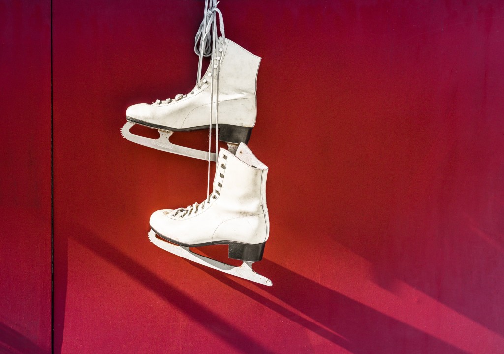 ice skates hanging on red wall