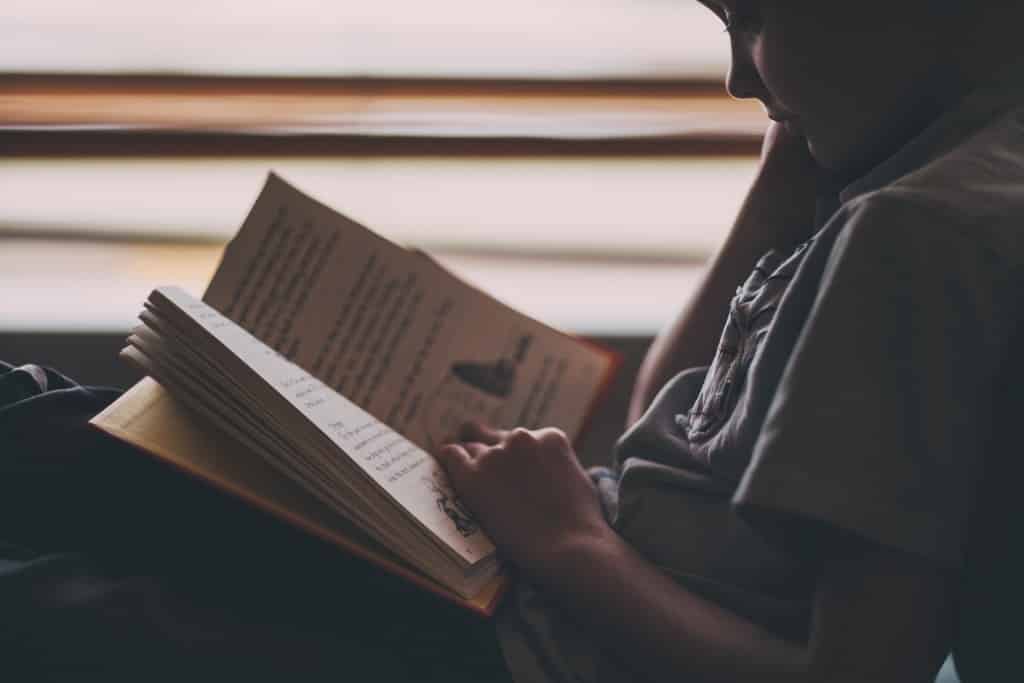 young boy reading chapter book